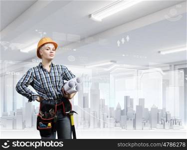 Young blond woman builder with projects in hand. Urban construction