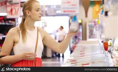 Young blond woman buying products at the supermarket