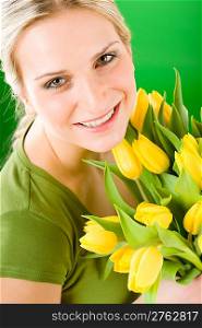 Young blond woman hold yellow tulips flower close up portrait