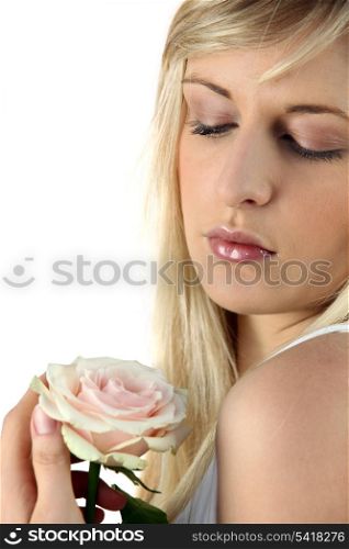 Young blond woman holding a rose