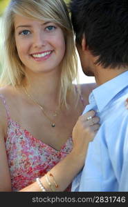 Young blond woman holding man&acute;s shirt