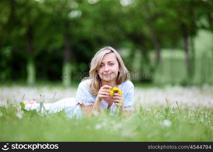 Young blond woman in blue dress in the park