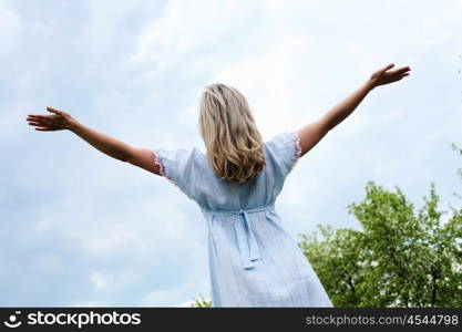 Young blond woman in blue dress in the park