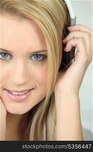 Young blond woman listening to music with headphones