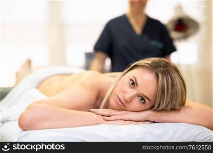 Young blond woman lying on a stretcher at a physical therapy center.. Woman lying on a stretcher at a physical therapy center.