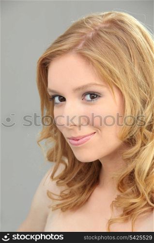 Young blond woman with shy smile