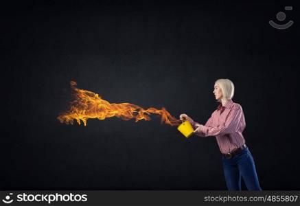 Young blond woman with yellow bucket in hands. Girl splashing fire flames