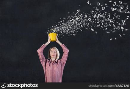 Young blond woman with yellow bucket in hands. Woamn splashing charcters from bucket