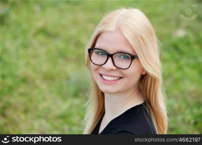 Young blonde girl with glasses outside smiling