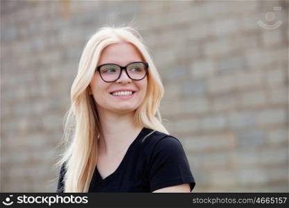 Young blonde girl with glasses outside smiling