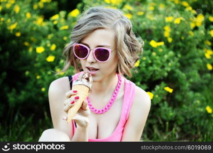 Young blonde hipster girl eating a delicious ice cream in summer hot weather in sunglasses have fun and good