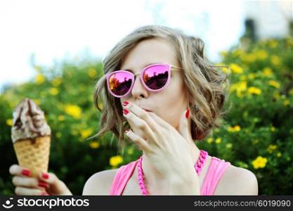 Young blonde hipster girl eating a delicious ice cream in summer hot weather in sunglasses have fun and good
