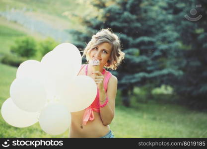 Young blonde hipster girl eating a delicious ice cream in summer hot weather have fun and good mood. Filtered instagram styled photo.