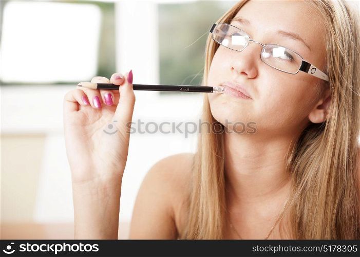Young blonde student thinking holding a pen