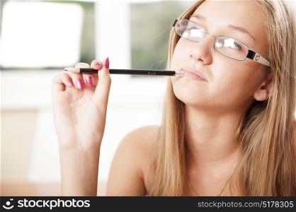 Young blonde student thinking holding a pen