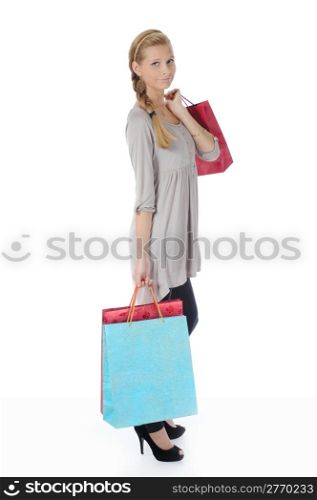 young blonde woman in a full-length with a paper shopping bags. Isolated on white background