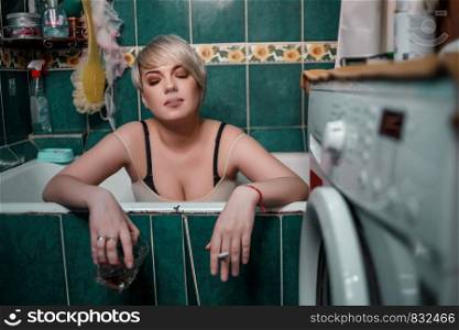 young blonde woman in the bathroom sitting drinking whiskey and Smoking cigarettes