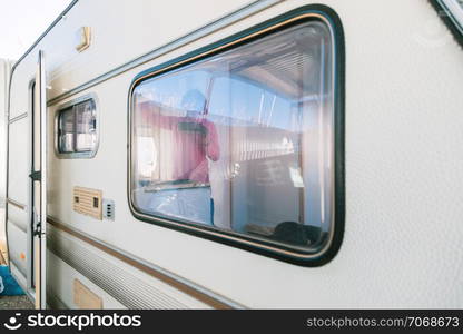 Young blonde woman painting and restoring caravan