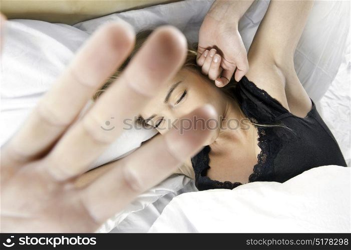 Young blonde woman streching in bed after waking up
