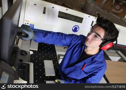 young blue collar in factory with computer