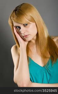 young blue-eyed blonde on a gray background