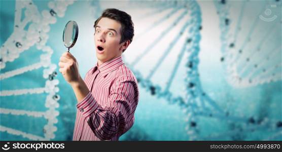 Young botanist. Young man in casual looking in magnifier