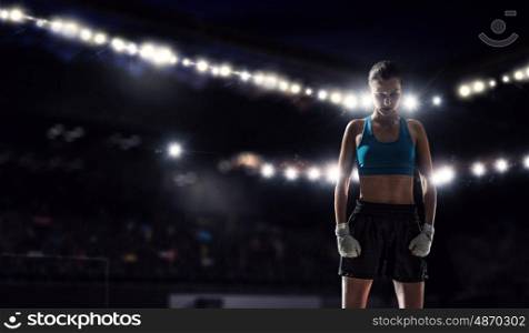 Young boxer woman at ring. Young pretty boxer woman standing in lights of sport arena