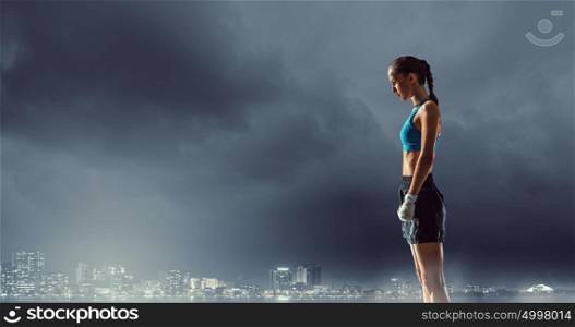 Young boxer woman outdoor. Young boxer woman standing outdoors against city landscape