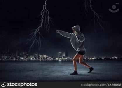 Young boxer woman training. Young boxer woman standing outdoors against city landscape