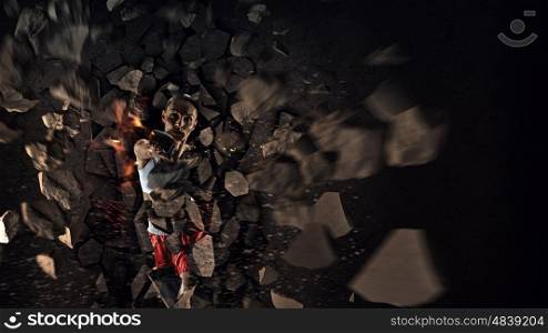 Young boxer woman. Young boxer woman breaking concrete wall with kick