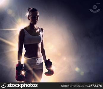 Young boxer woman. Young pretty boxer woman standing in light flashes