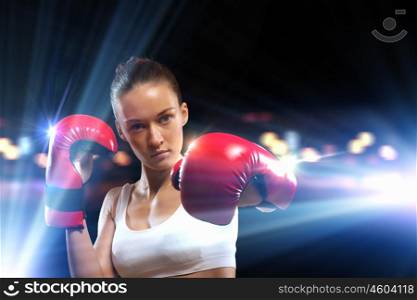 Young boxer woman. Young pretty boxer woman standing in light flashes