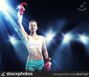 Young boxer woman. Young pretty boxer woman standing in light flashes