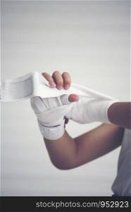 young boxer wrapping hands with boxing wraps