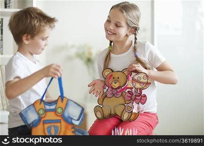 Young boy and girl holding their toy bags