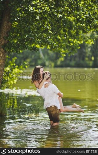 Young boy and girl standing on the shore of green lake.. Happy couple on the background of nature 6306.
