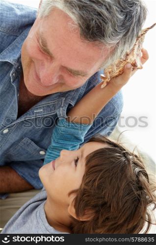 Young boy and grandfather with seashell