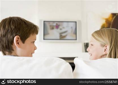 Young boy and young girl in living room with flat screen television