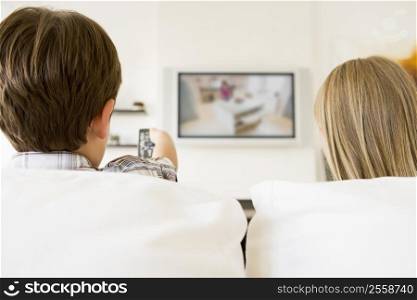 Young boy and young girl in living room with remote control and flat screen television