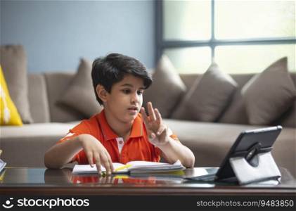 YOUNG BOY ANSWERING TO HIS TEACHER DURING HIS ONLINE CLASS