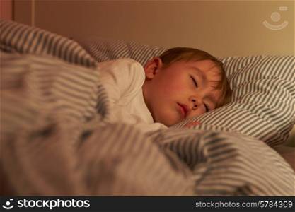 Young Boy Asleep In Bed At Night