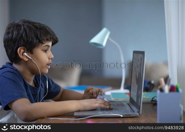 Young boy attending online class on his laptop during lockdown
