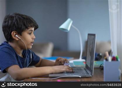 Young boy attending online class on his laptop during lockdown
