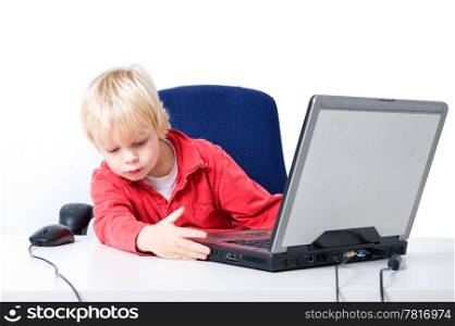 Young boy behind a laptop, closing the DVD-Rom drive with his hand