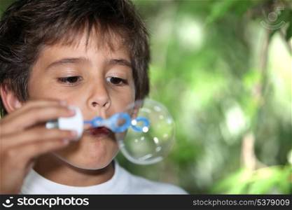 Young boy blowing bubbles