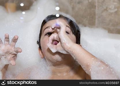 Young boy blowing bubbles in bubble bath