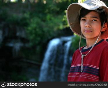 Young boy by a waterfall