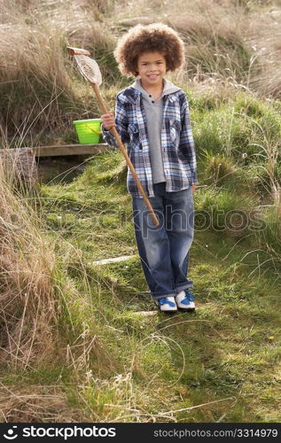 Young Boy Carrying Fishing Net At Seaside