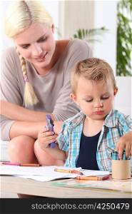 Young boy coloring with wax crayons