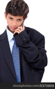 Young boy dressed in a adult&rsquo;s business suit
